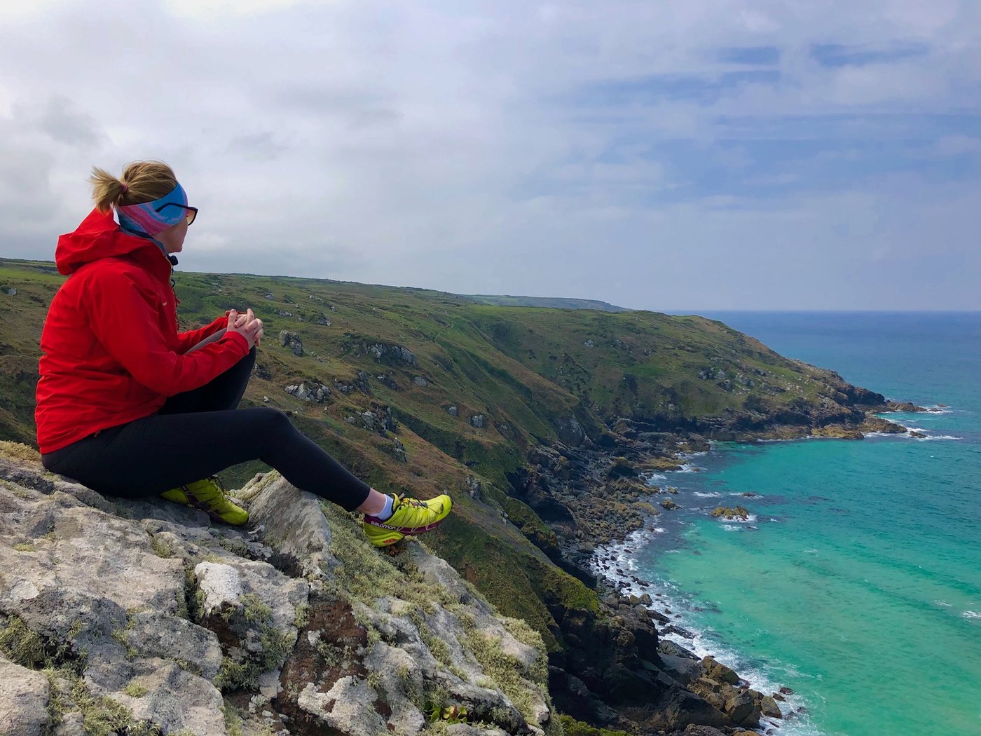 Christina Kehl sitting on a rock above sea cliffs