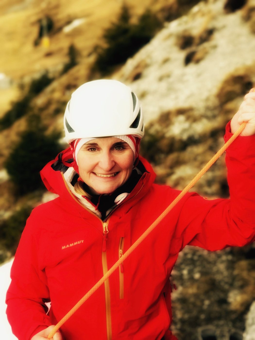 Christina Kehl laughing, with climbing helmet and rope