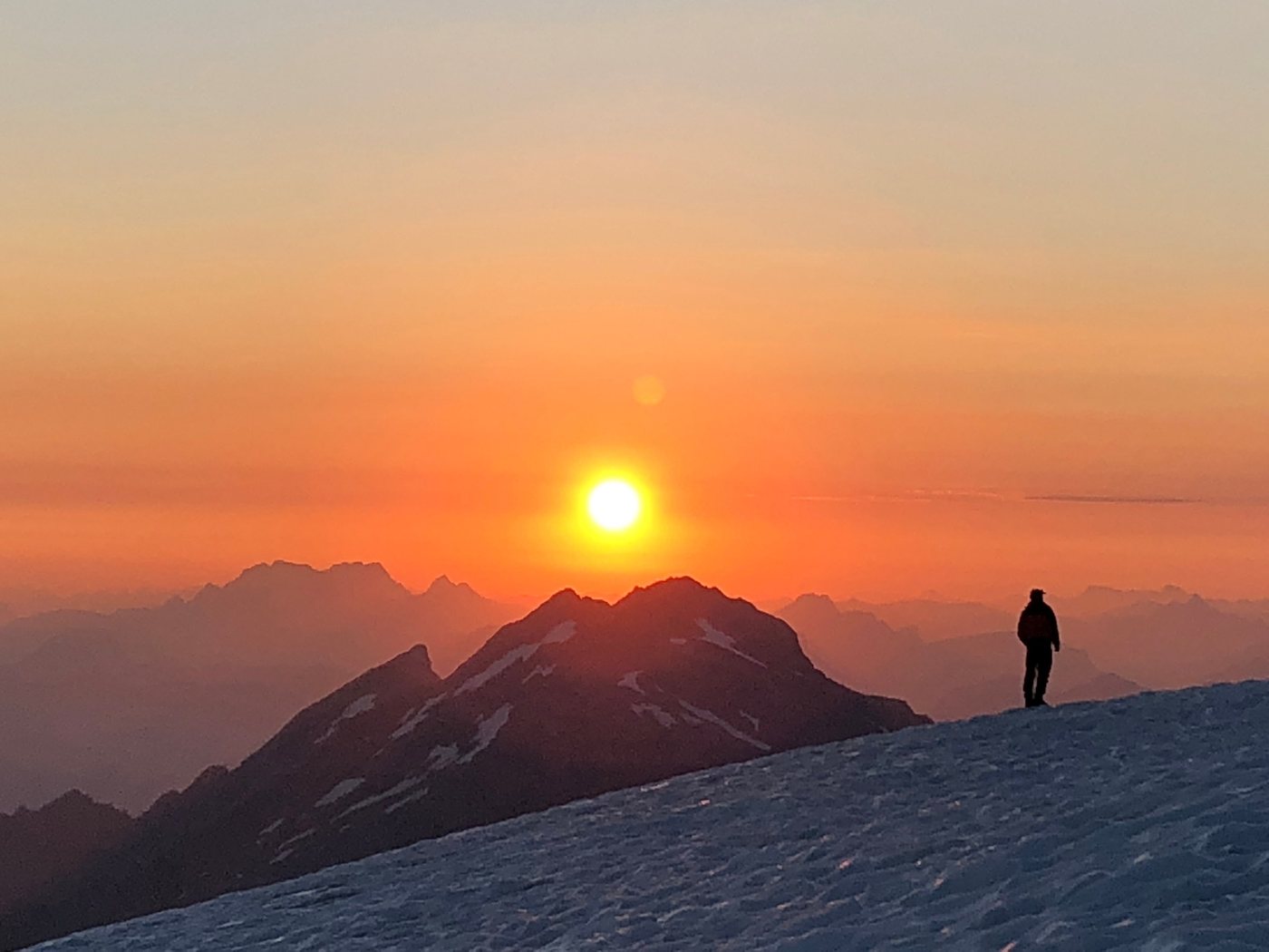 Sunrise over the mountains, a person on a snowy ridge