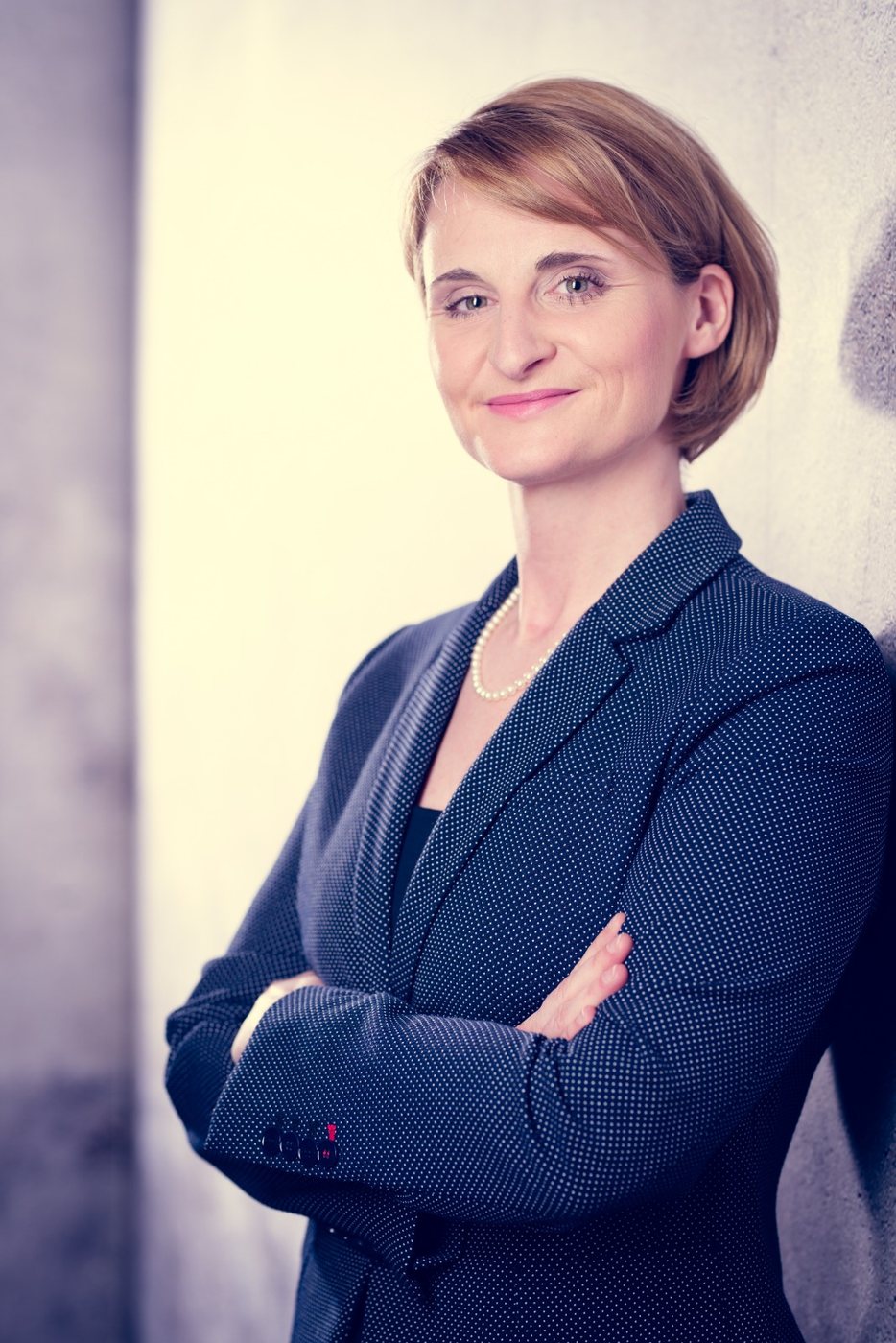 Portrait of Christina Kehl in a navy blazer with arms crossed