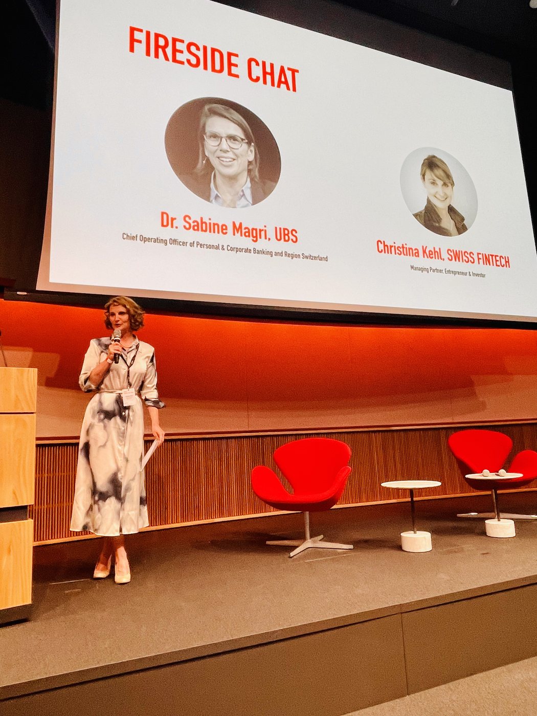 Christina Kehl on stage in front of a “Fireside Chat” screen