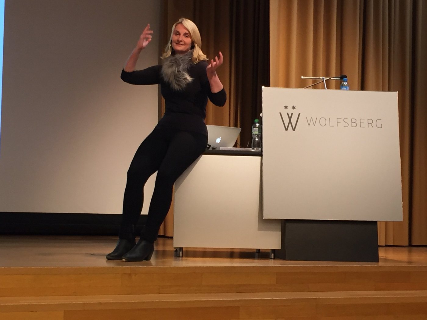 Christina Kehl speaking on stage next to the lectern